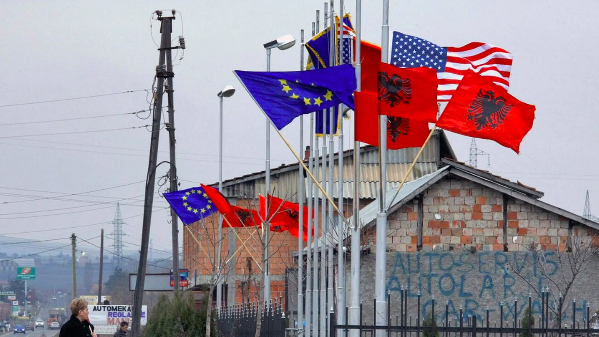 Флаги Албании, США и Евросоюза рядом с административным зданием в албанской части Косово