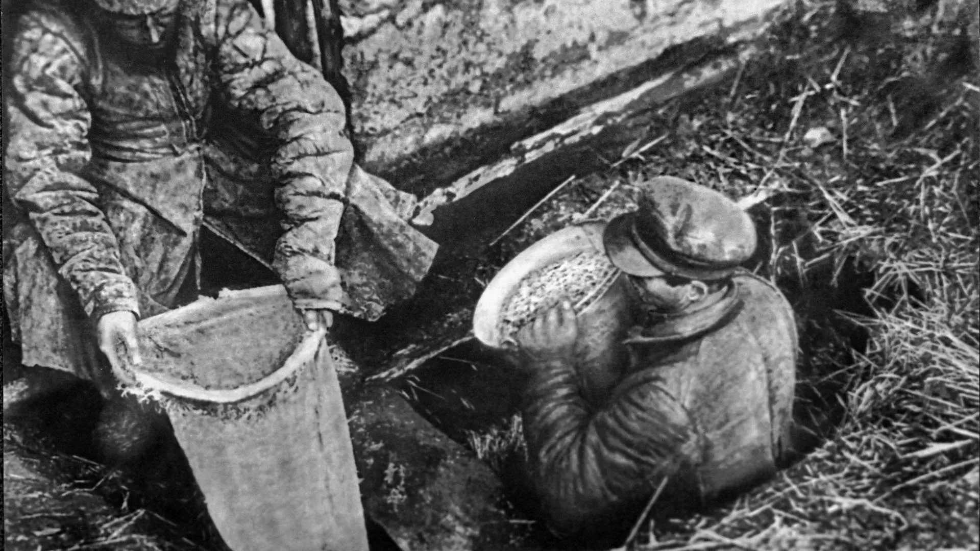 Работники ОГПУ извлекают из ямы спрятанное зерно, 1932 год. Государственный музей политической истории России