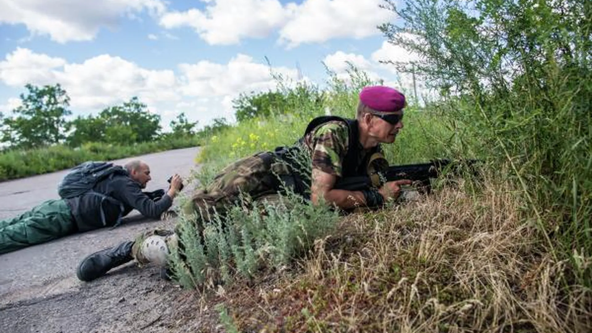 Журналист «Комсомольской правды» Дмитрий Стешин (слева) и командир отряда ополченцев с позывным «Собр» во время обстрела снайпером возле поселка Восточного