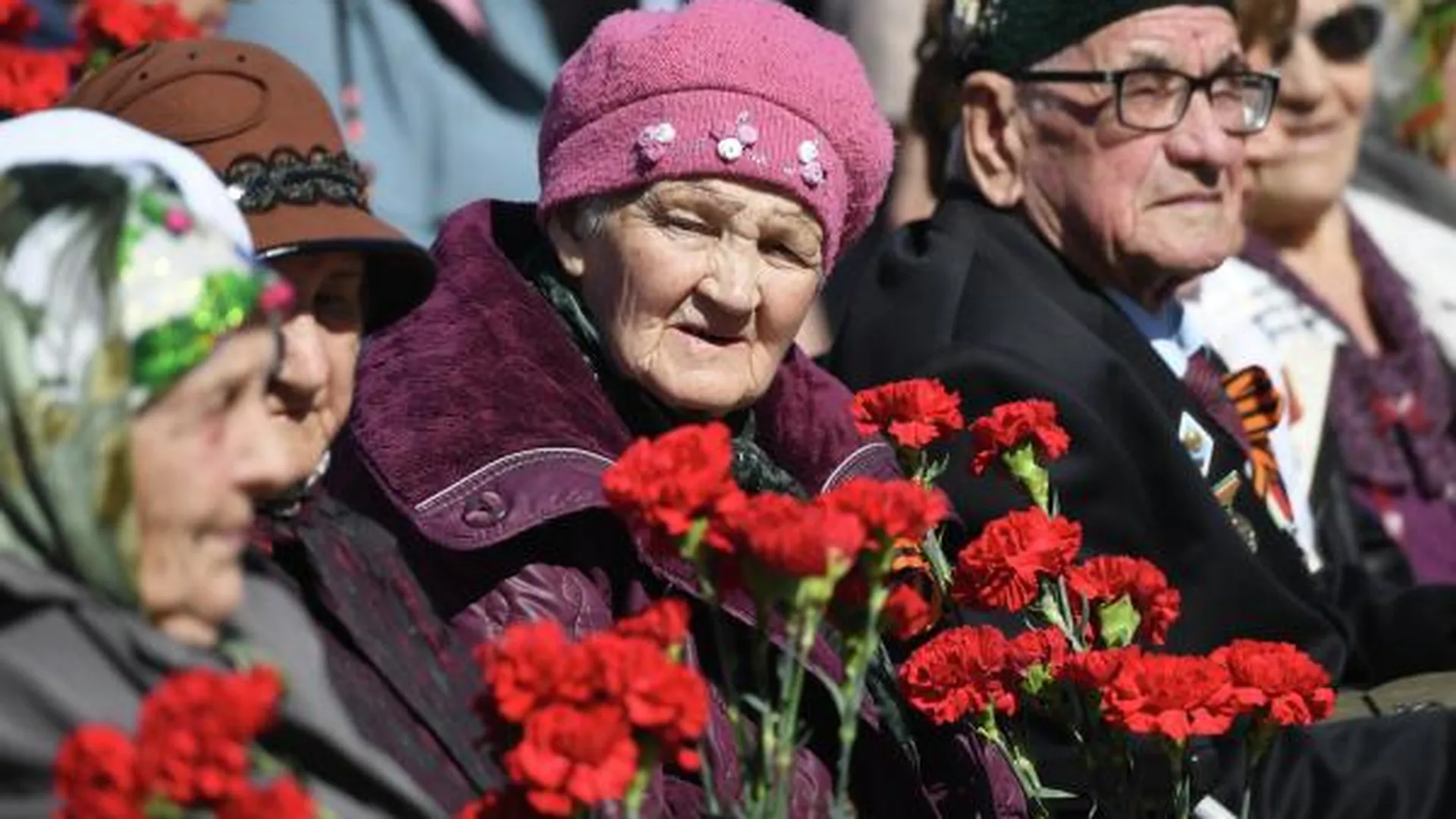 Женщины у дома ветеранов в Казани во время поздравления ветеранов в рамках акции «Парад у дома ветерана», приуроченной к 77-й годовщине Победы в Великой Отечественной войне